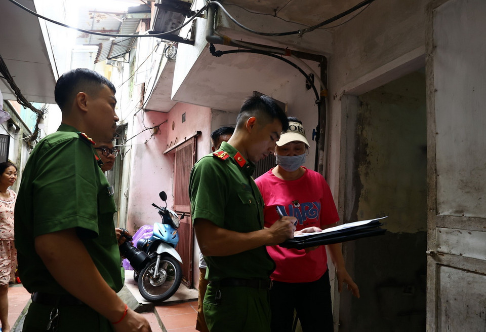 Công an phường Chương Dương vận động người dân tại ngõ 661 Bạch Đằng di dời khỏi khu vực nguy hiểm (ảnh chụp lúc 13h20 ngày 10/9). (Ảnh: Huy Hùng/TTXVN)