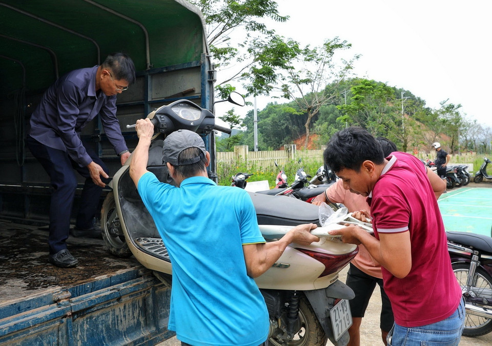 Người dân vận chuyển xe máy bị ngập nước đến địa điểm Nhà văn hóa tổ 13, phường Yên Ninh để sửa chữa. (Ảnh: Tuấn Anh/TTXVN)