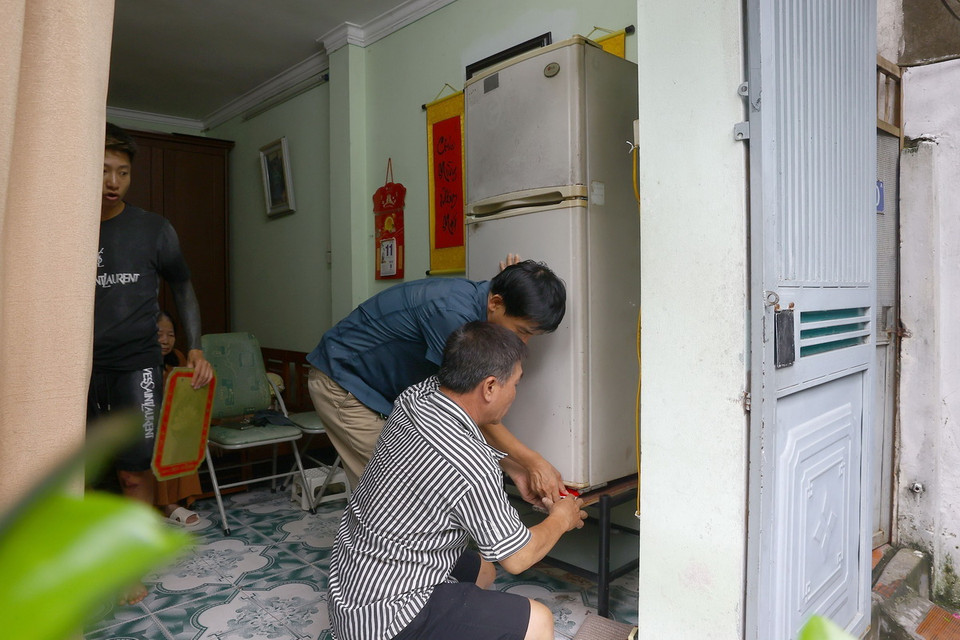 Một gia đình kê tủ lạnh lên cao tránh nước ngập. (Ảnh: Huy Hùng/TTXVN)