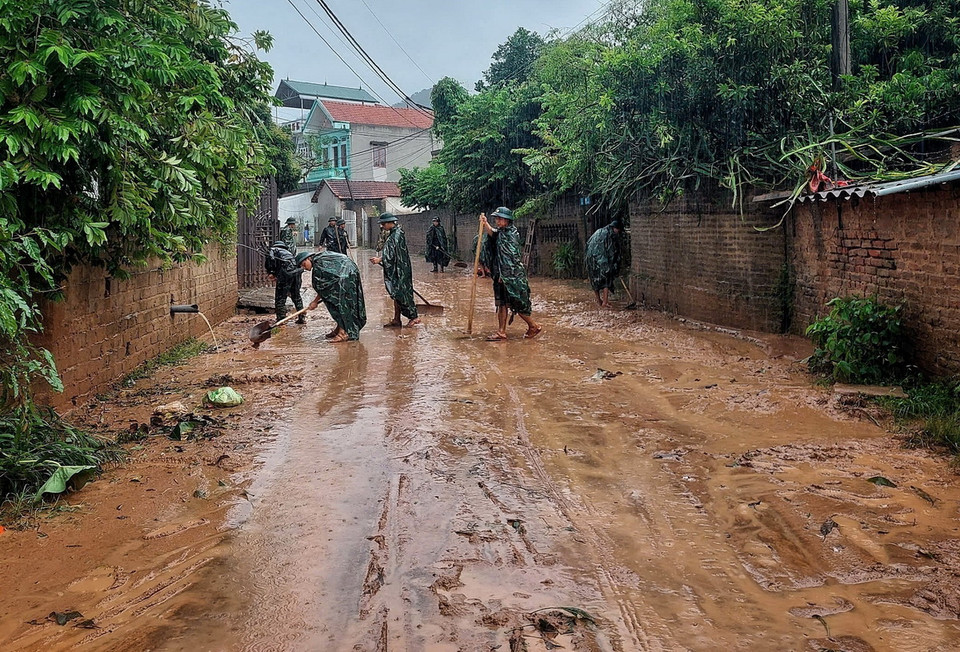 Cán bộ, chiến sỹ Ban Chỉ huy quân sự huyện Sơn Động giúp dân dọn dẹp môi trường sau khi lũ rút. (Ảnh: TTXVN phát)