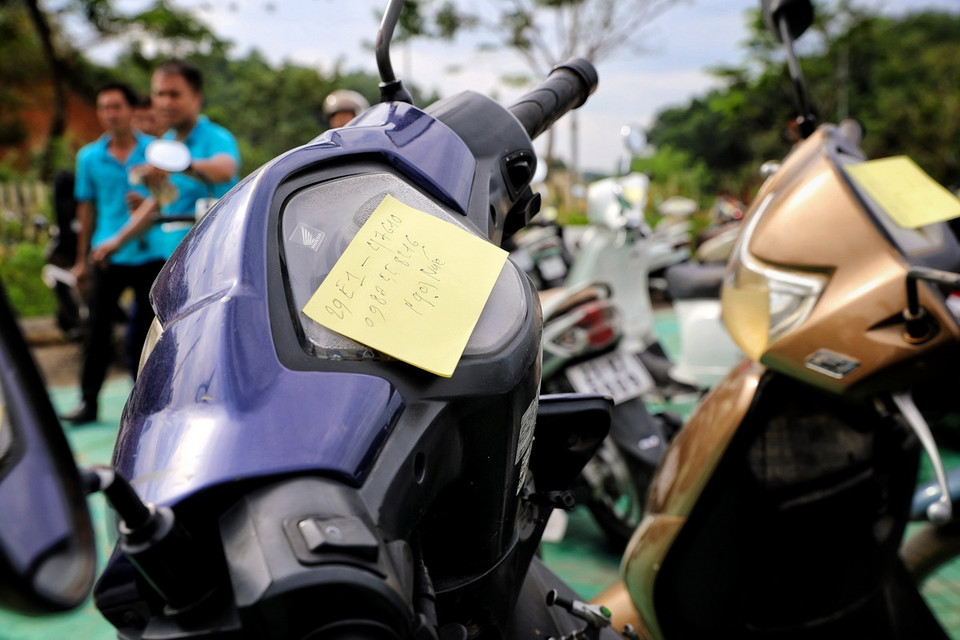 Những chiếc xe máy đều được đánh số thứ tự và kèm theo số điện thoại. Khi nào xe sửa xong, nhân viên sẽ gọi chủ xe đến nhận. (Ảnh: Tuấn Anh/TTXVN)