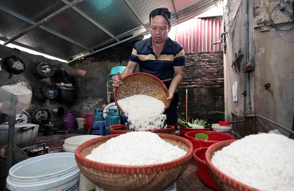 Làng nghề bánh dầy Quán Gánh tại thôn Thượng Đình, xã Nhị Khê, Thường Tín, Hà Nội có từ lâu đời được người dân nhiều đời gìn giữ. Để có sản phẩm ngon chất lượng, những người thợ làm bánh phải qua nhiều công đoạn từ khâu chọn gạo, ngâm gạo đúng thời gian, vo kỹ, đồ xôi vừa chín, giã nhuyễn, pha chế nhân mặn, ngọt với những hương liệu nào phù hợp…. Gạo được ngâm và vo kỹ sau đó để ráo nước trước khi nấu xôi. (Ảnh: Trần Việt/TTXVN)