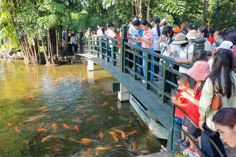 Người dân thăm ao cá Bác Hồ trong Khu di tích Chủ tịch Hồ Chí Minh. (Ảnh: Hoàng Hiếu/TTXVN)