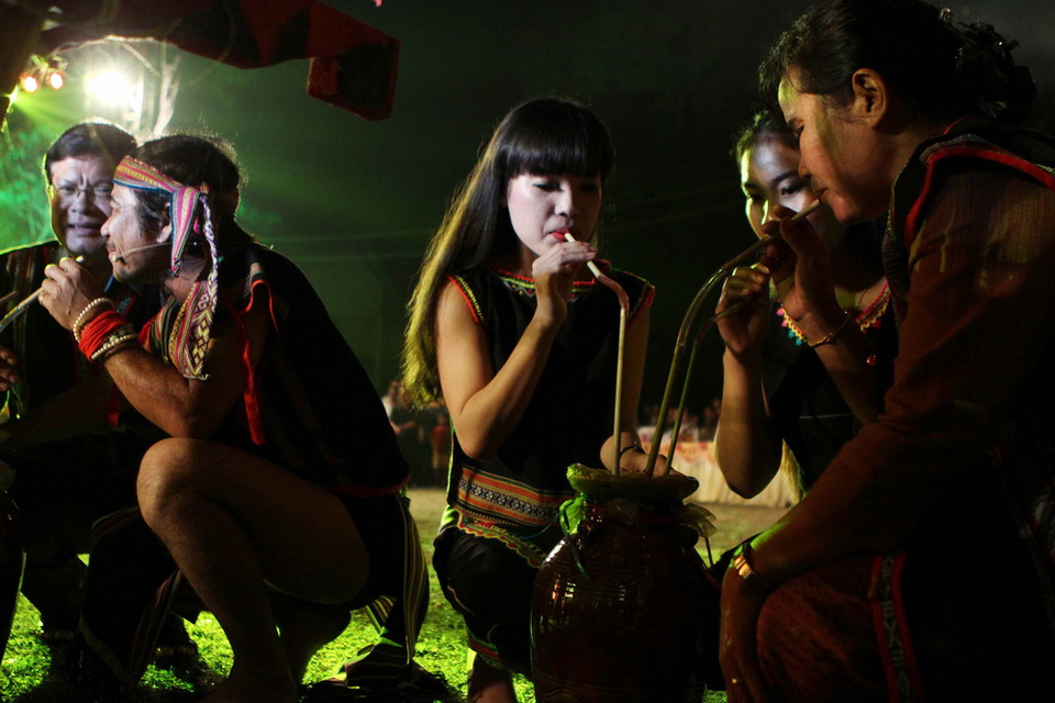 Già làng, trưởng bản và các chàng trai cô gái bên ghè rượu cần. (Ảnh: Dương Giang/TTXVN)