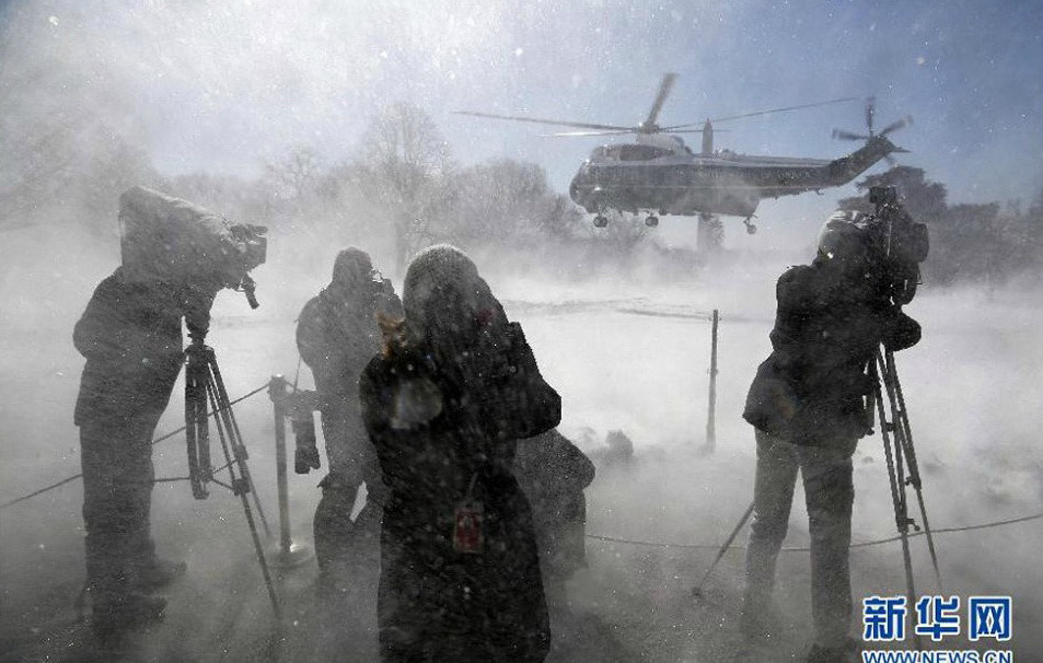 Hình ảnh những phóng viên đứng dưới tuyết chụp ảnh khoảnh khắc chiếc trực thăng Marine One chở Tổng thống Obama cất cánh vào ngày 6/3. (Nguồn: Xinhua)