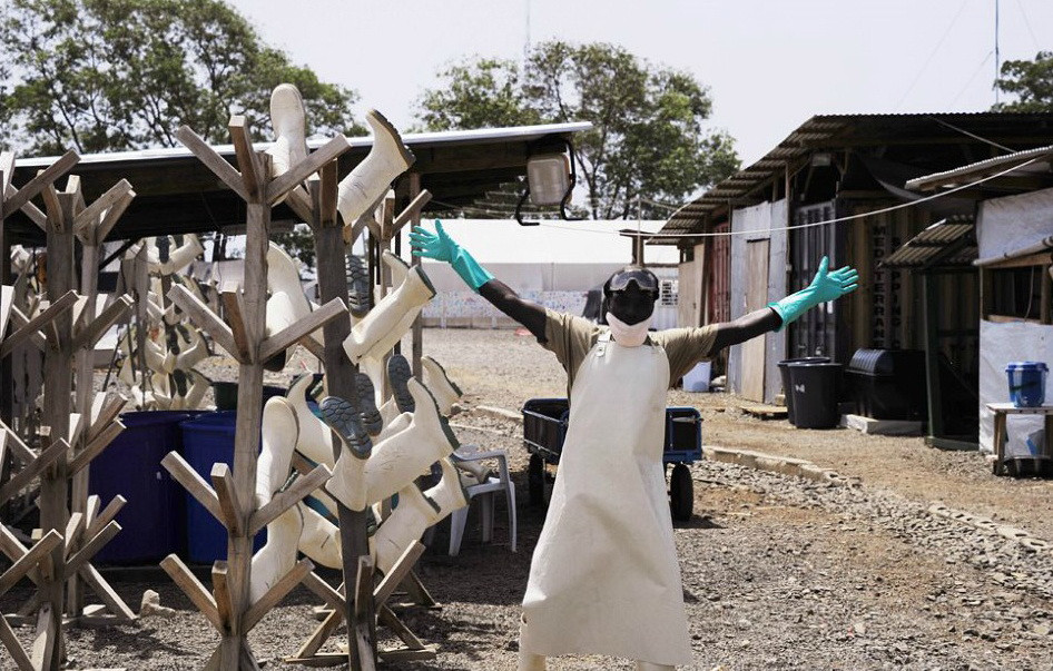 Một công nhân người Libya vui mừng giơ cả hai cánh tay lên khi vừa dỡ đi một trung tâm điều trị Ebola. (Nguồn: Xinhua)