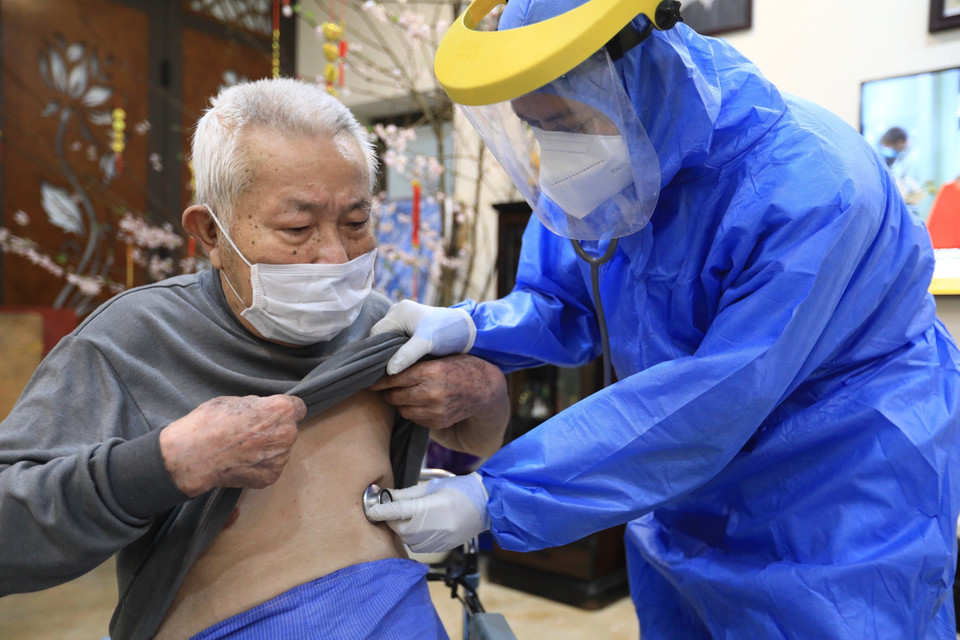 Nhân viên y tế phường Hàng Bài kiểm soát sức khỏe cho người cao tuổi trước tiêm chiều 29/1. (Ảnh: Hoàng Hiếu/TTXVN)