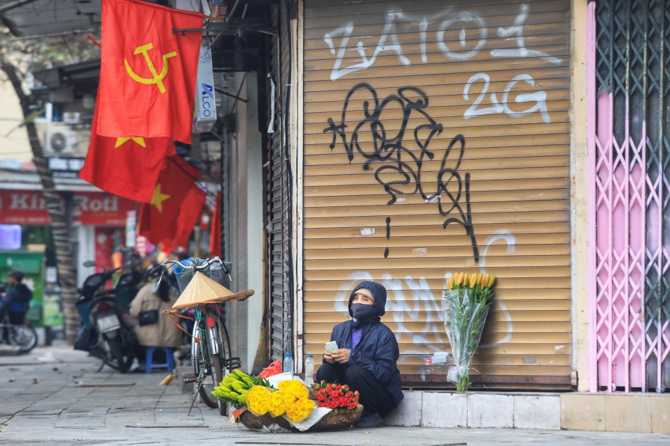 Một người bán hoa hàng rong bán hàng ngày đầu năm. (Ảnh: Tuấn Anh/TTXVN)