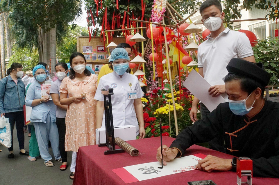 Khu vực ông đồ tặng chữ thư pháp cho các nhân viên y tế và người bệnh tại đường hoa của bệnh viện. (Ảnh: Thu Hương/TTXVN)