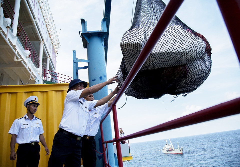 Cán bộ, chiến sỹ nhà giàn DK1 nhận quà Tết được cần cẩu chuyển lên. (Ảnh: Hồng Đạt/TTXVN)