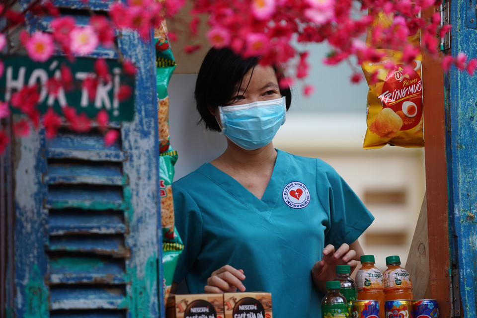 Các điều dưỡng, y tá của bệnh viện tranh thủ ghé đường hoa chụp ảnh lưu niệm trước khi vào ca trực. (Ảnh: Thu Hương/TTXVN)