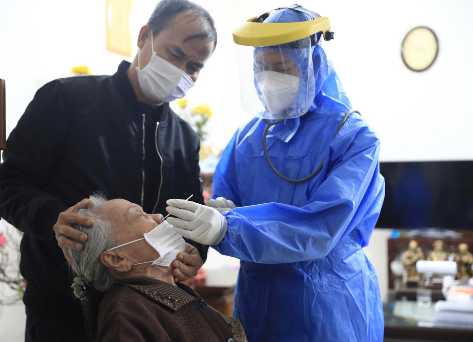 Bác sỹ Nguyễn Đức Dương (trạm y tế phường Hàng Bài, Hoàn Kiếm) lấy mẫu xét nghiệm sàng lọc SARS-CoV-2 cho người cao tuổi trước tiêm. (Ảnh: Hoàng Hiếu/TTXVN)