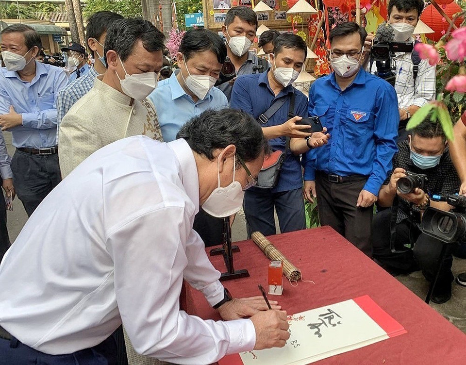 Bí thư Thành ủy Thành phố Hồ Chí Minh Nguyễn Văn Nên viết thư pháp tặng bệnh nhân nhân dịp năm mới. (Ảnh: Thu Hương/TTXVN)