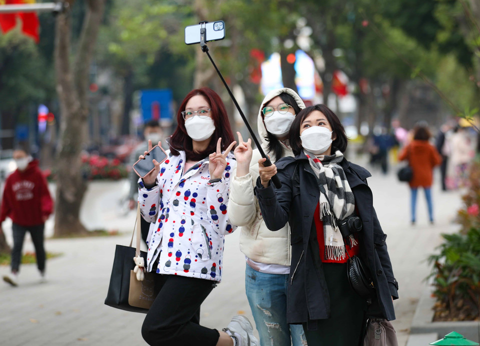 Các bạn trẻ lưu lại những khoảnh khắc đón Xuân. (Ảnh: Thanh Tùng/TTXVN)