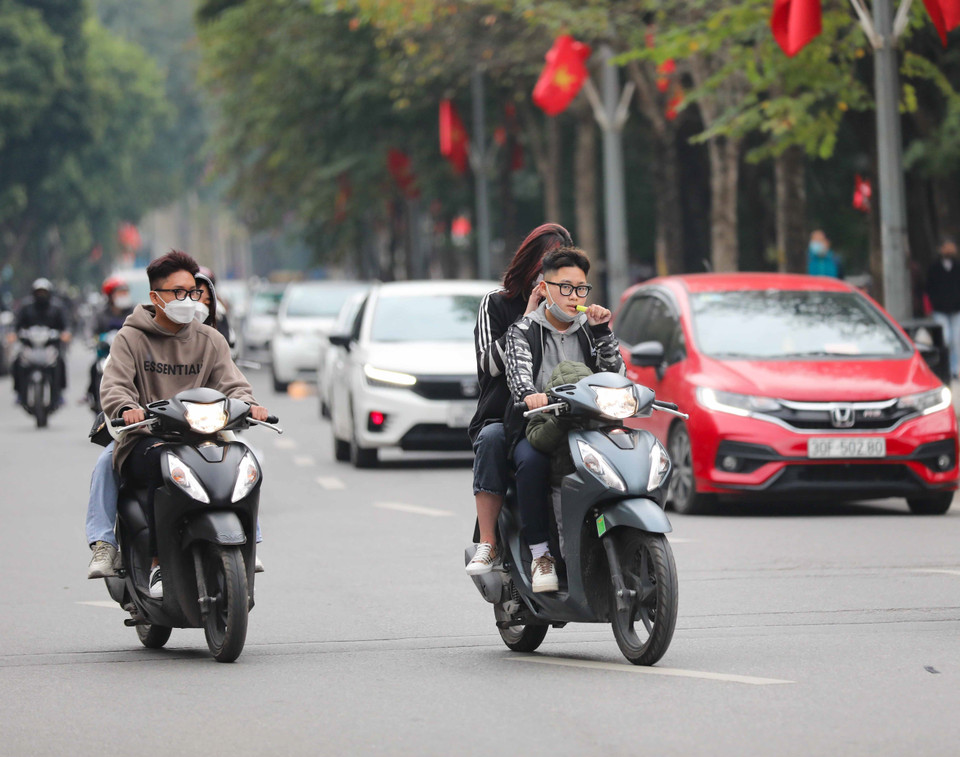 Vô tư không đội mũ bảo hiểm và không đeo khẩu trang. (Ảnh: Thanh Tùng/TTXVN)