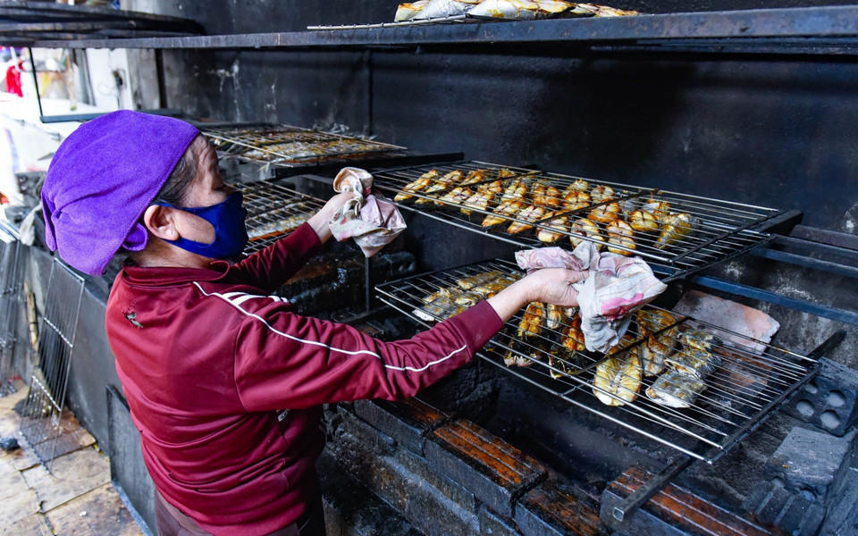 Trong quá trình nướng cá, phải trở, lật thường xuyên để cá không bị cháy. (Ảnh: TTXVN phát)