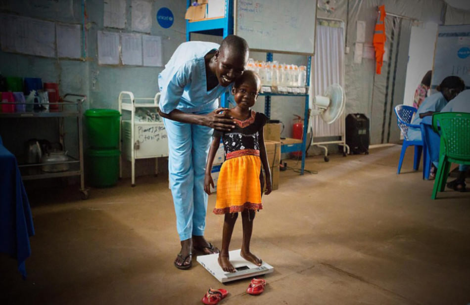 Ban đầu, cơ thể cô bé rất yếu, gần như không thể ngồi vững, càng không nói đến chuyện đứng lên. Hiện tại, cô bé đã có thể đứng dậy và mỉm cười. (Nguồn: QQ)