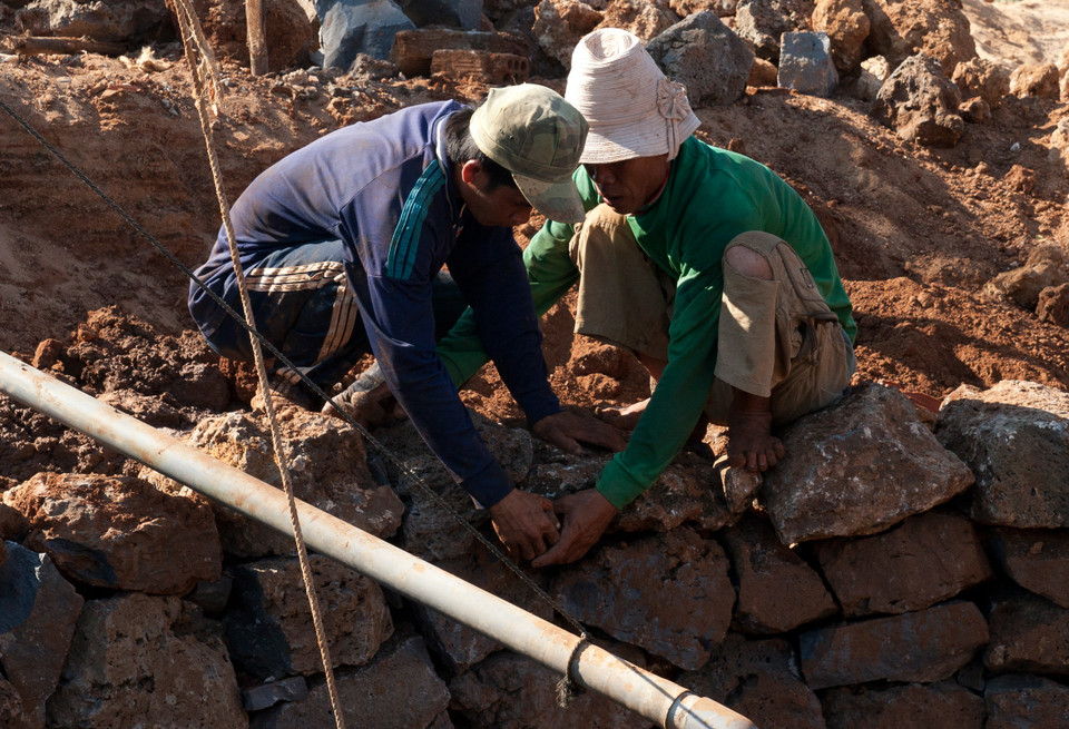 Việc xếp đá kè làm bờ thành càng phải công phu, tỉ mỉ, nếu không tính toán kĩ thì thành giếng sẽ đổ sụp. (Ảnh: Doãn Đức/Vietnam+)