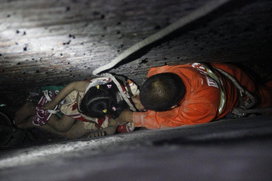 Khoảng 20 giờ ngày 7/6, đội cứu hộ huyện Nhân Thọ, thành phố Mi Sơn, tỉnh Tứ Xuyên, Trung Quốc nhận được tin báo một bé gái 5 tuổi bị rơi từ tầng hai, kẹt trong khe giữa hai ngôi nhà. (Nguồn: Chinadaily)