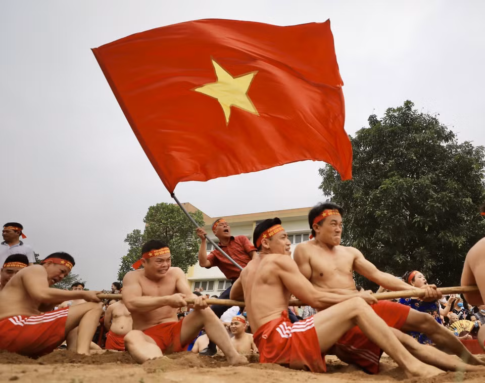 “Kéo co ngồi” không chỉ thể hiện sức khỏe của mỗi người chơi mà còn là tinh thần đoàn kết giữa người kéo co, người chạy cờ, người cổ động. (Ảnh: Nhật Anh/TTXVN)