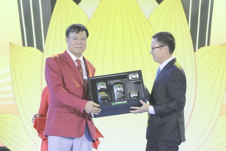 Đại diện các nhà tài trợ trao tượng trưng tài trợ cho Đoàn thể thao Việt Nam. (Ảnh: Minh Quyết/TTXVN)