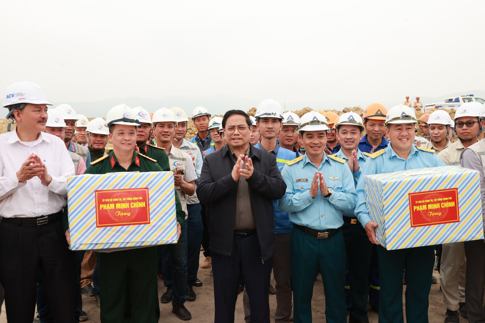 Thủ tướng Phạm Minh Chính tặng quà cho công nhân Dự án đầu tư xây dựng mở rộng Cảng hàng không Điện Biên. (Ảnh: Dương Giang/TTXVN)