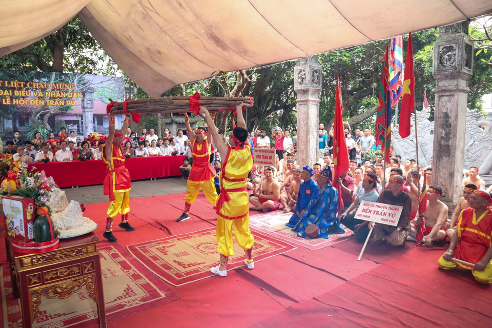 Ba đội trưởng của ba đội nâng bó song mây dài khoảng 50m (một loại cây dẻo dai và chắc chắn, được dùng để làm dây kéo co) trong phần nghi lễ. (Ảnh: Nguyễn Thuỳ Dương/TTXVN phát)