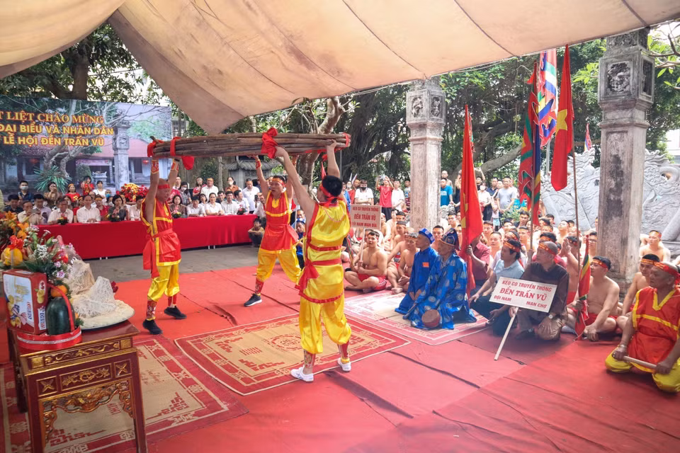 Ba đội trưởng của ba đội nâng bó song mây dài khoảng 50m (một loại cây dẻo dai và chắc chắn, được dùng để làm dây kéo co) trong phần nghi lễ. (Ảnh: Nguyễn Thuỳ Dương/TTXVN phát)