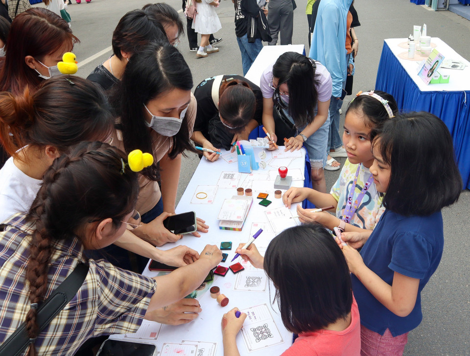 Các em nhỏ trải nghiệm trang trí bưu thiếp tại Lễ hội. (Ảnh: Nguyễn Thùy Dương/TTXVN phát)