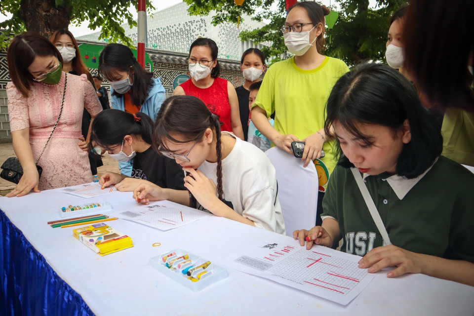 Các em nhỏ chơi giải ô chữ tại Lễ hội. (Ảnh: Nguyễn Thùy Dương/TTXVN phát)