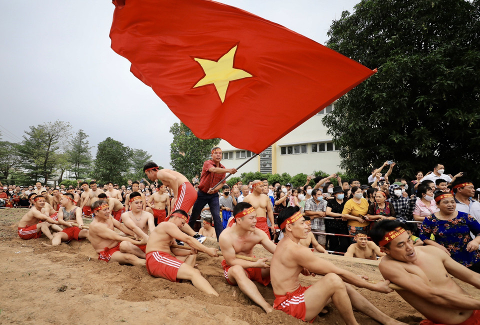 “Kéo co ngồi” không chỉ thể hiện sức khỏe của mỗi người chơi mà còn là tinh thần đoàn kết giữa người kéo co, người chạy cờ, người cổ động. (Ảnh: Nhật Anh/TTXVN)