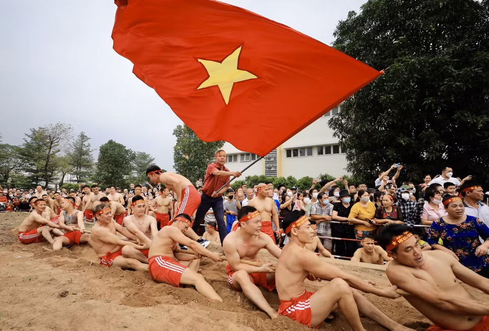 “Kéo co ngồi” không chỉ thể hiện sức khỏe của mỗi người chơi mà còn là tinh thần đoàn kết giữa người kéo co, người chạy cờ, người cổ động. (Ảnh: Nhật Anh/TTXVN)