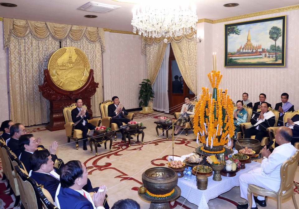 Chủ tịch nước Võ Văn Thưởng và Tổng Bí thư, Chủ tịch nước Lào Thongloun Sisoulith cùng đại biểu hai nước tại Lễ buộc chỉ cổ tay cầu may nhân dịp Tết cổ truyền Bunpimay của Lào. (Ảnh: Thống Nhất/TTXVN)