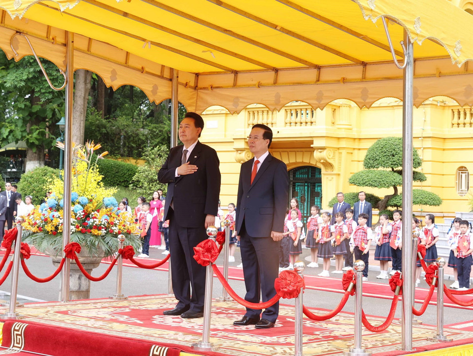 Chủ tịch nước Võ Văn Thưởng và Tổng thống Hàn Quốc Yoon Suk Yeol nghe quân nhạc cử Quốc thiều hai nước. (Ảnh: Thống Nhất/TTXVN)