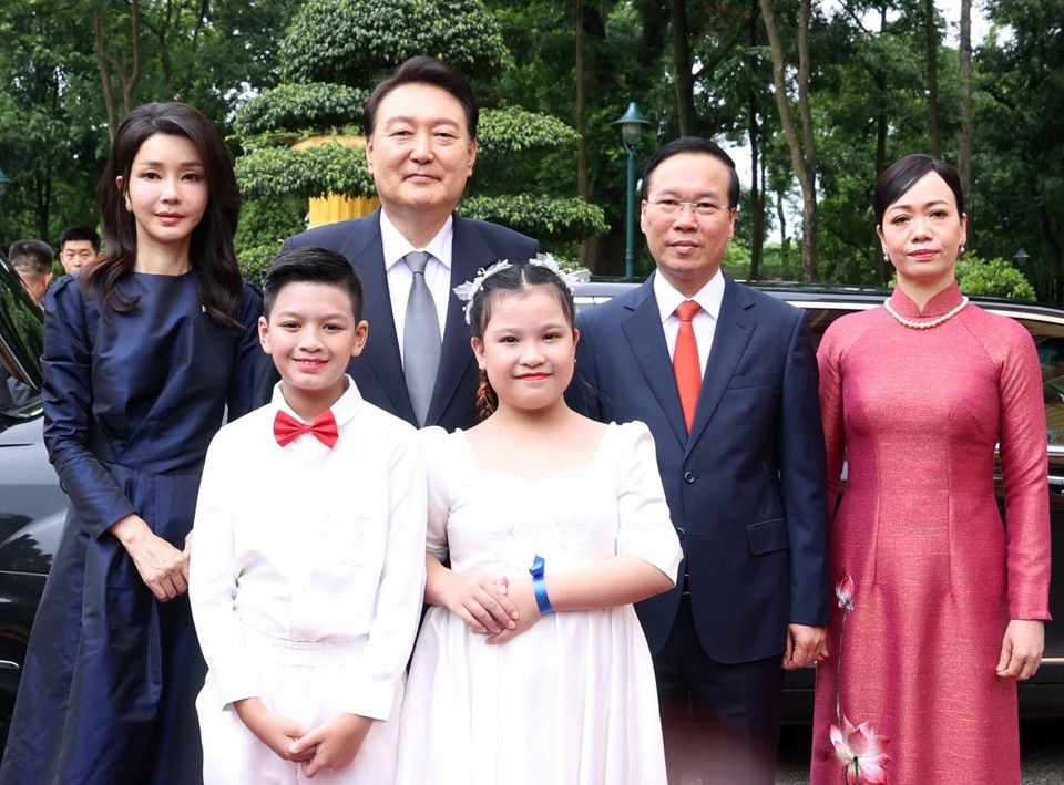 Chủ tịch nước Võ Văn Thưởng và Phu nhân cùng Tổng thống Hàn Quốc Yoon Suk Yeol và Phu nhân với thiếu nhi Thủ đô tại lễ đón. (Ảnh: Thống Nhất/TTXVN)