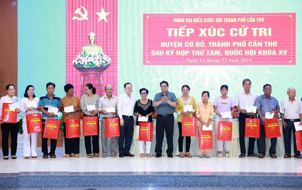 Thủ tướng Phạm Minh Chính tặng quà cho các các gia đình chính sách huyện Cờ Đỏ. (Ảnh: Dương Giang/TTXVN)