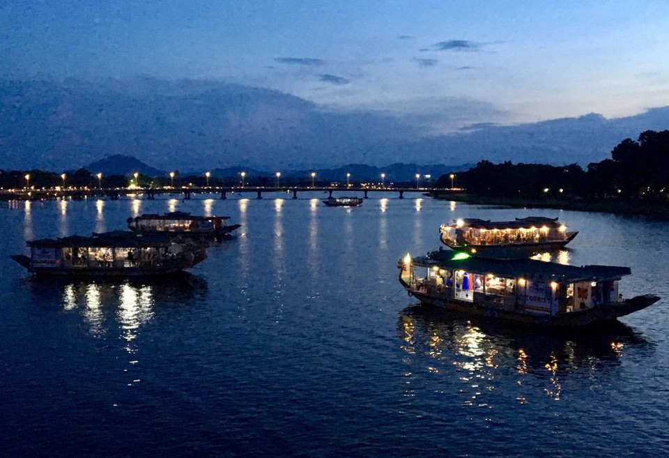 Từ chiều tà cho đến khi đêm xuống, xuống thuyền nghe ca Huế hoặc đứng hai bên bờ sông Hương nhìn xuống dòng sông, du khách như được lạc vào cảnh sắc thần tiên mơ mộng với những ngọn đèn lấp lánh phát ra từ những chiếc thuyền ca Huế giữa dòng sông Hương. (Ảnh: Quốc Việt/TTXVN)