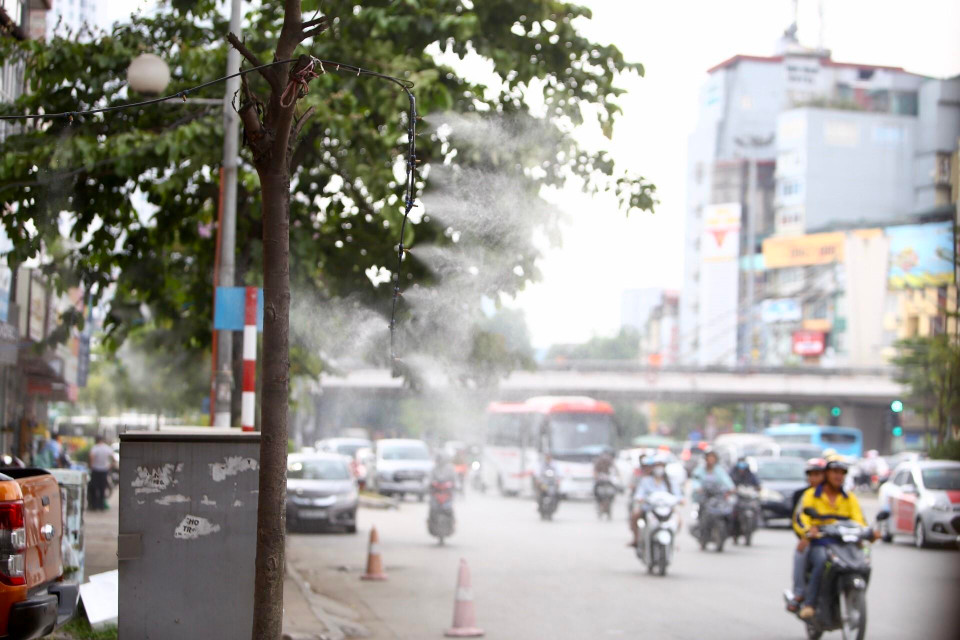 Nhiều cửa hàng ở Hà Nội phải sử dụng vòi phun sương để giảm nhiệt. (Ảnh: Minh Quyết/TTXVN)