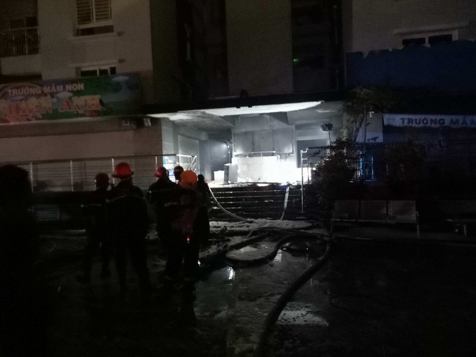 Cảnh sát Phòng cháy chữa cháy phun nước dập tắt đám cháy phát ra từ tầng hầm chung cư. (Ảnh: Thành Chung/TTXVN)