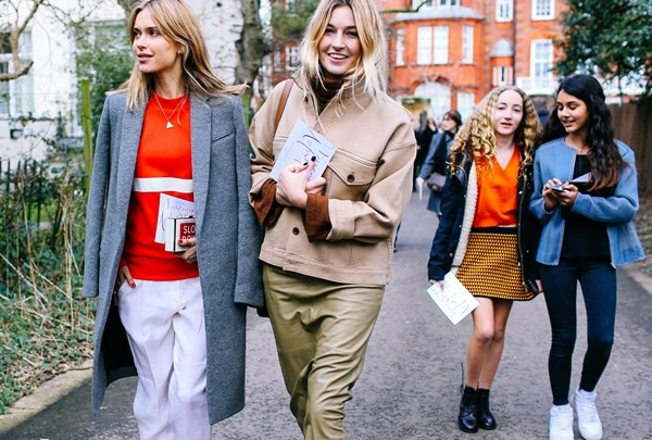 Cô nàng Camille Charrière (phải) - chủ nhân trang blog Camille over the Rainbow - diện áo khoác của H&amp;M cùng áo cổ lọ màu nâu, chân váy Joseph và túi của Ralph Lauren bên cạnh cô nàng blogger Pernille Teisbaek (trái) diện áo khoác màu ghi xám cùng ví cầm tay của Anya Hindmarch. (Nguồn: Đẹp/Vietnam+)