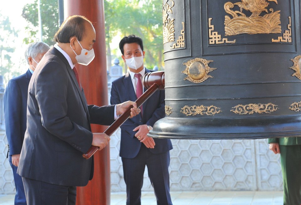 Chủ tịch nước Nguyễn Xuân Phúc thỉnh chuông tại Nghĩa trang Liệt sỹ Quốc gia Vị Xuyên. (Ảnh: Minh Đức/TTXVN)