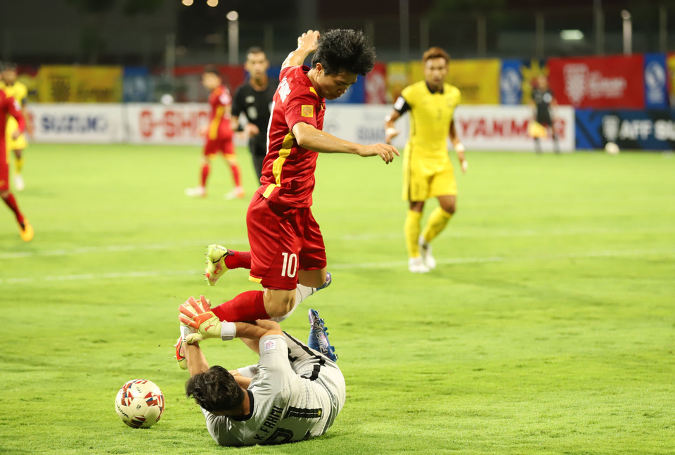 Thủ môn đội tuyển Malaysia nỗ lực cản đường bóng trong chân của tiền đạo Công Phượng . (Ảnh: TTXVN)