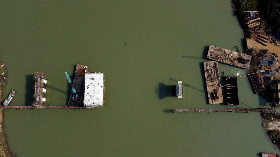 Cầu Vĩnh An đang tập trung thi công các trụ chính ở dưới sông và đẩy nhanh 2 trụ biên, cố gắng hợp long nhịp cầu chính vào ngày 30/4/2022. (Ảnh: Huy Hùng/TTXVN)