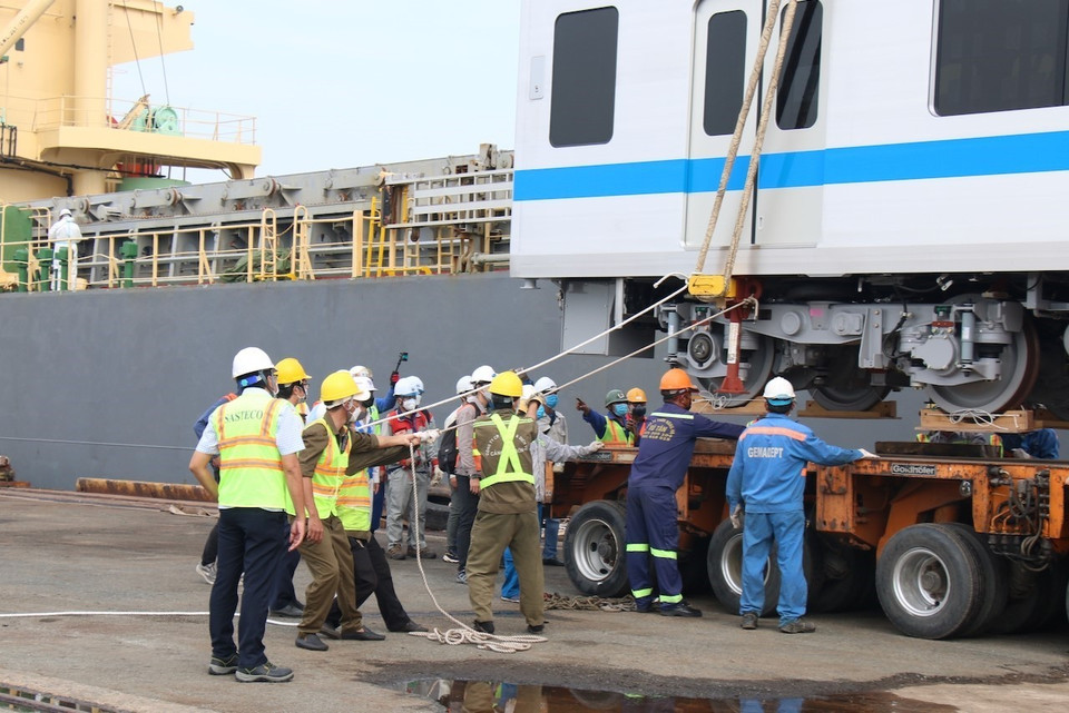 Các kỹ sư xem xét, căn chỉnh trước khi đặt toa xe xuống xe vận chuyển siêu trường, siêu trọng. (Ảnh: Tiến Lực/TTXVN)