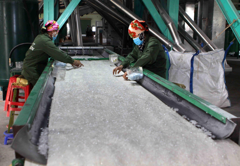 Công ty Cổ phần Đầu tư và Phát triển Hà Tiến (Nghệ An) chuyên sản xuất mảnh PET (mảnh nhựa trắng) tái chế từ các loại vỏ chai nhựa, mỗi năm xuất khẩu khoảng 4000 tấn ra thị trường Nhật Bản và Đài Loan phục vụ cho ngành công nghiệp dệt may. (Ảnh: Thanh Tùng/TTXVN)