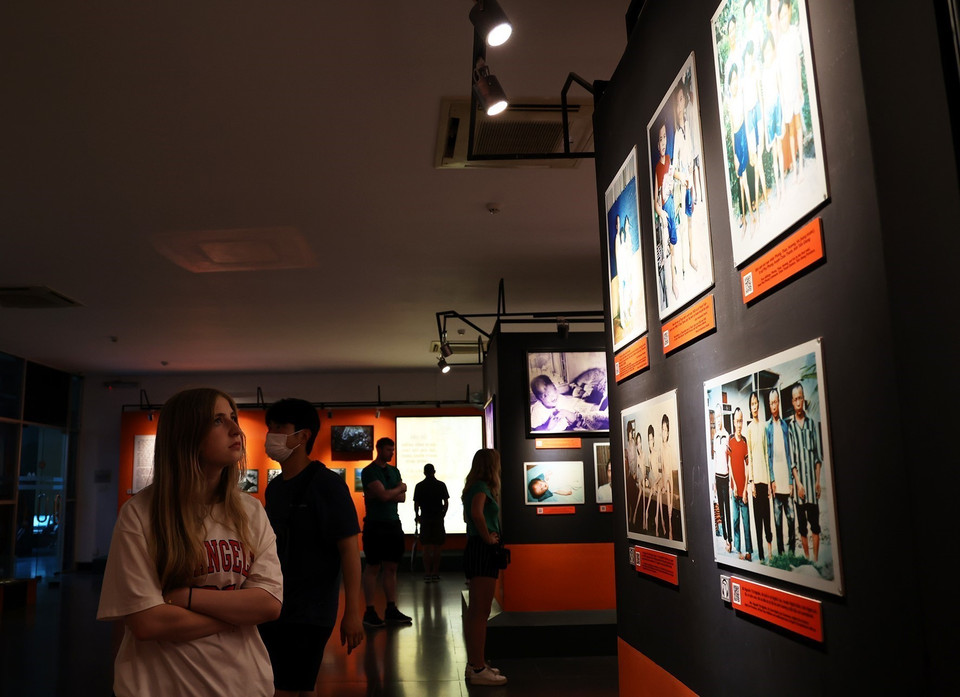 Du khách quốc tế tham quan phòng trưng bày "Nỗi đau da cam Việt Nam." (Ảnh: Hồng Đạt/TTXVN)