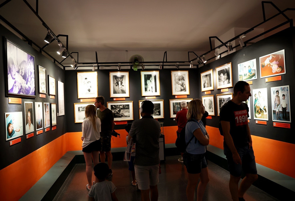 Du khách quốc tế tham quan phòng trưng bày "Nỗi đau da cam Việt Nam." (Ảnh: Hồng Đạt/TTXVN)