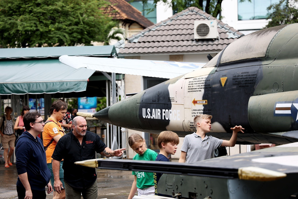 Du khách quốc tế xem chiếc máy bay chiến đấu của Mỹ sử dụng trong cuộc chiến tranh xâm lược Việt Nam. (Ảnh: Hồng Đạt/TTXVN)