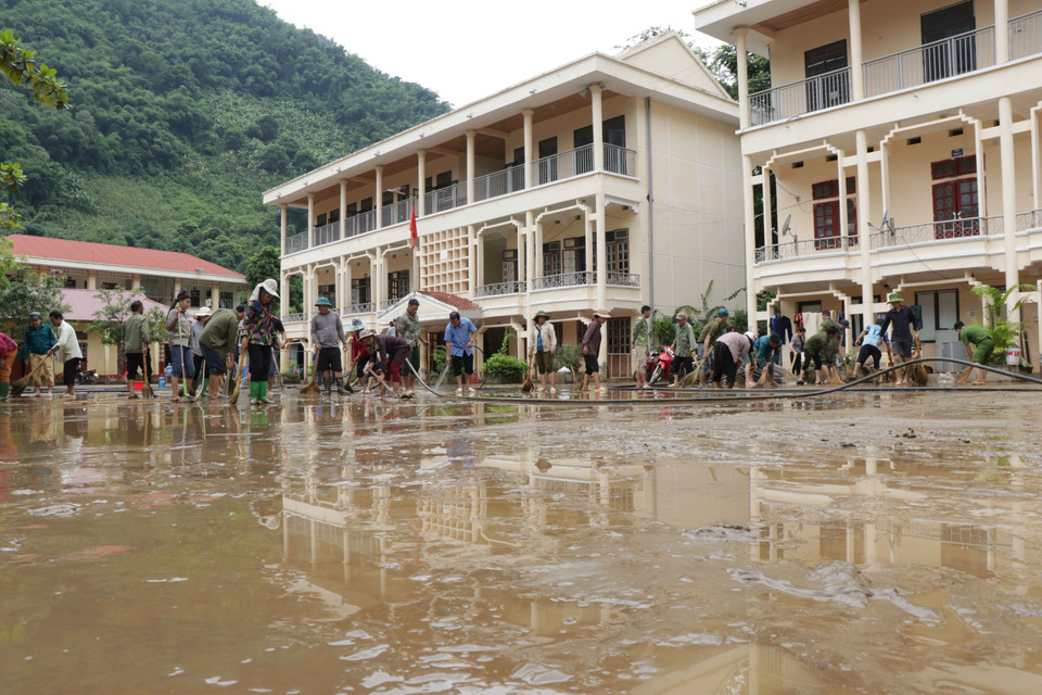 Chính quyền địa phương đã huy động người dân, lực lượng chức năng dọn dẹp, khắc phục hậu quả mưa lũ tại trường Trung học cơ sở Tạ Khoa. (Ảnh: Hữu Quyết/TTXVN)