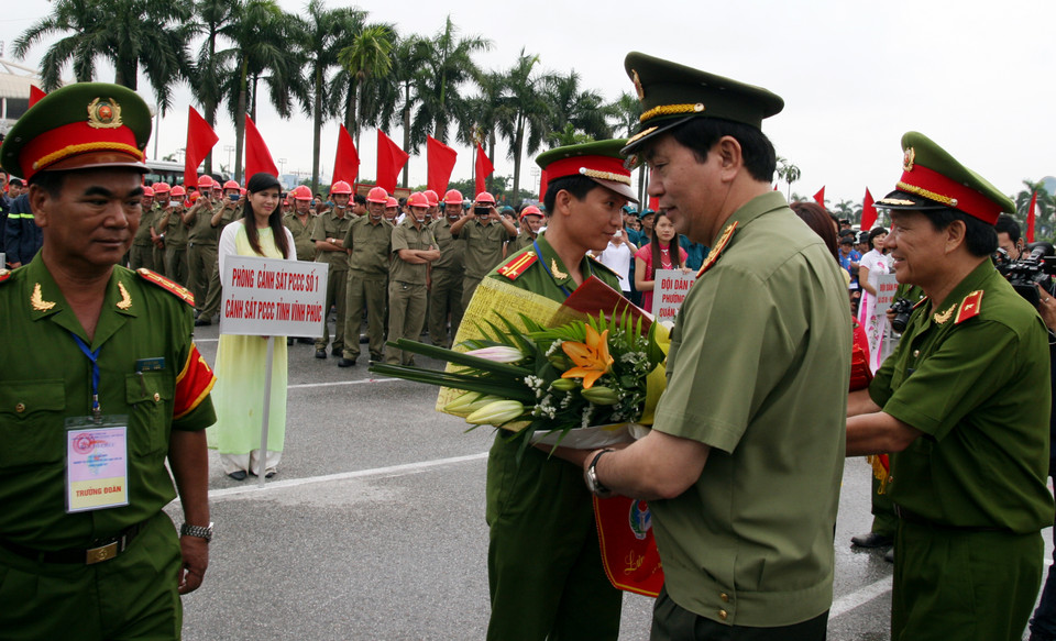 Bộ trưởng Bộ Công an Trần Đại Quang tặng hoa, trao cờ lưu niệm cho các đoàn. (Ảnh: Doãn Đức/Vietnam+)